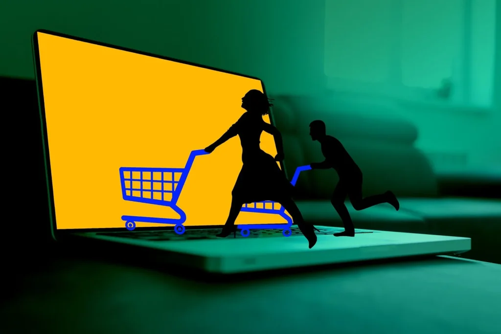 A silhouette of a man and a woman running with blue shopping carts across a laptop keyboard, emerging from a bright yellow screen.